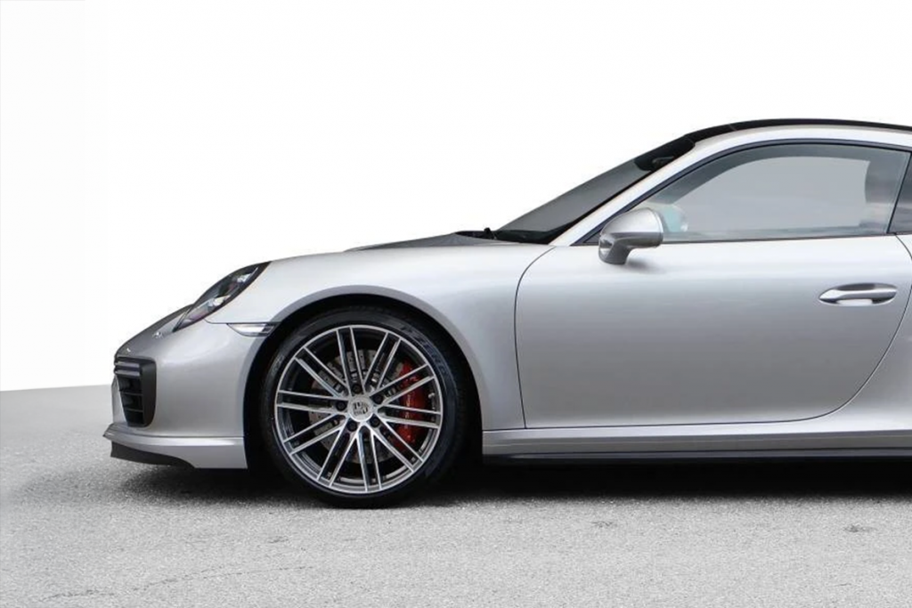 Seitenansicht eines silbernen Porsche mit auffälligen Felgen und roten Bremssätteln, die als Vorlage für ein individuelles Werbemittel von Präsentstudio Soennecken dienen